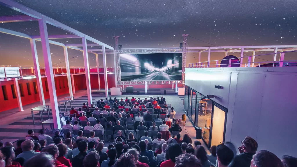 Wil je deze zomer naar een bioscoop, maar niet binnen zitten? Check deze rooftop cinema’s De bioscoop is een leuk uitje, maar in de zomer is het vaak ‘geen optie’ omdat je liever niet in een donkere ruimte gaat zitten als de zon schijnt en het warm is buiten. De oplossing? Rooftop cinema’s! Met deze rooftoplocaties sla je twee vliegen in één klap: je kunt genieten van een film én heerlijk buiten zitten. Zit je liever wel in een koele bios tijdens de hitte? Ook daar hebben we leuke tips voor. De leukste rooftop cinema’s Wij zetten de leukste rooftops voor je op een rij. Rooftop cinema – Pathe Leidsche Rijn Yes, Pathé heeft ook een rooftop! Daar kan je gewoon lekker onder de sterrenhemel naar je favoriete films kijken. De keuze ruim, net zoals altijd bij Pathe. Natlab Eindhoven – buitenfilm In Eindhoven kijk je buiten films bij Natlab. Je kunt daar je eigen comfy stoel meenemen en er is ruimte voor heel veel personen. En ook leuk: de tickets zijn maar 5 euro. Andere bijzondere bioscooplocaties Of wil je juist aan de warmte ontsnappen en lekker in een verkoelde bioscoop zitten? Dit zijn wat bijzondere locaties die je zeker wil checken: Cinema Roma in Wijchen Een prachtige bios, waar je zelfs eten kunt bestellen. Dit kan via de bestelsite of door op de serviceknop te drukken. De bestelling wordt in de zaal uitgeserveerd zodat jij als bezoeker alleen maar op de film hoeft te letten én kan genieten van je hapjes en drankjes. Houden we van. Forum Theater in Sittard Rooftop cinema Nederland